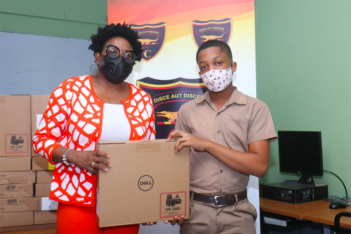 Ms Janet Silvera, Public Relations Officer for the Cornwall College Alumni Association of South Florida, presents one of the lab tops to a Cornwall College Student